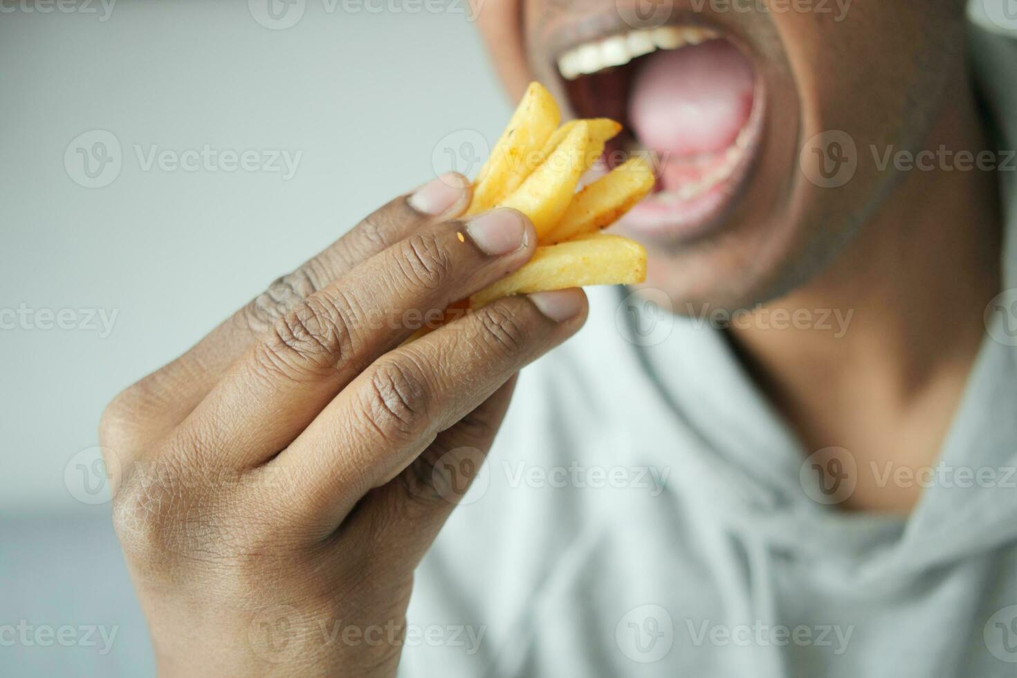 a fat man eating french fries while sited photo