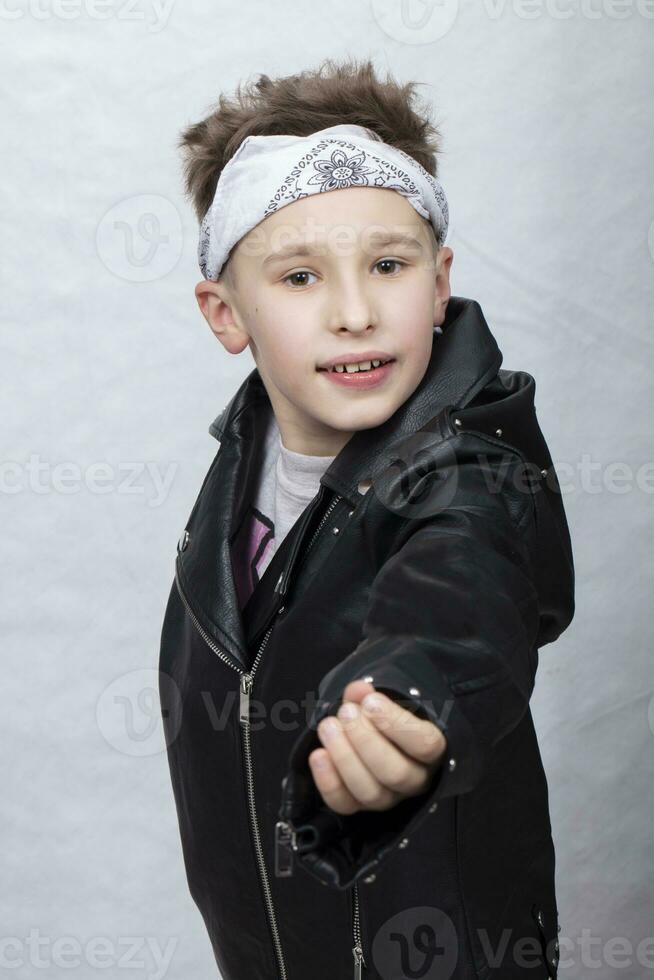 retrato de un chico en un cuero chaqueta y un vendaje en su cabeza. él sonrisas a el cámara. foto