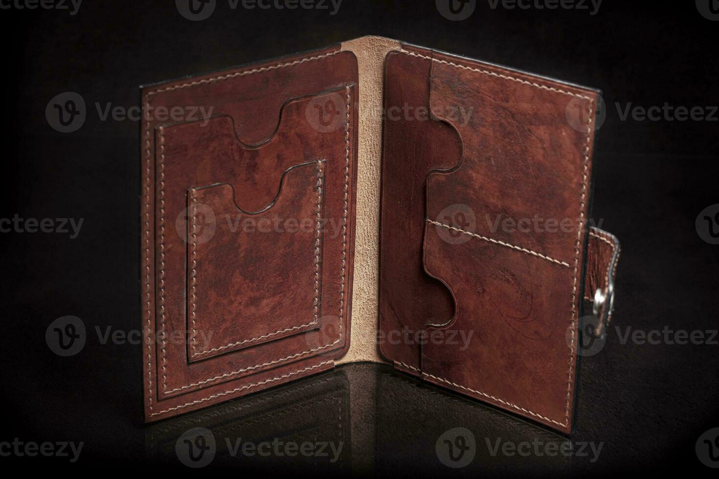 Leather open wallet in brown on a black background. photo