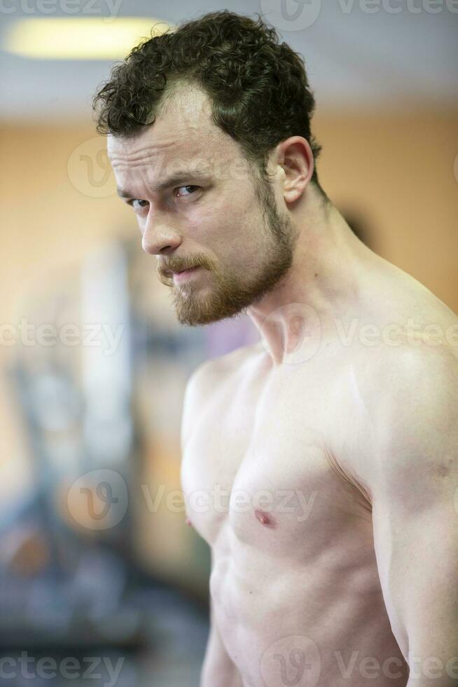 A young man of athletic build looks into the camera. photo
