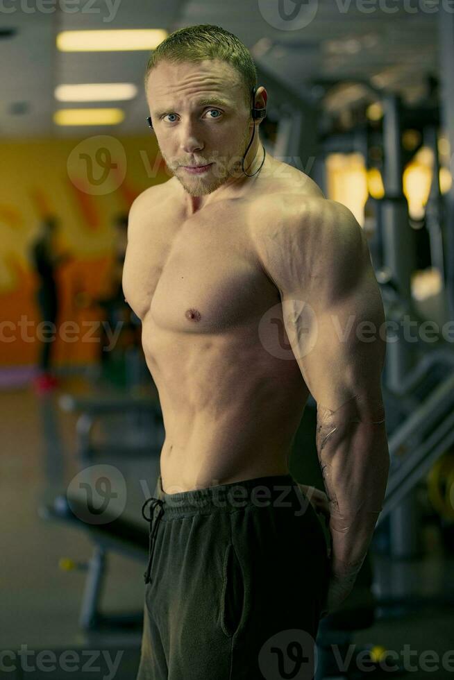 Handsome young man of athletic physique posing at the camera. photo