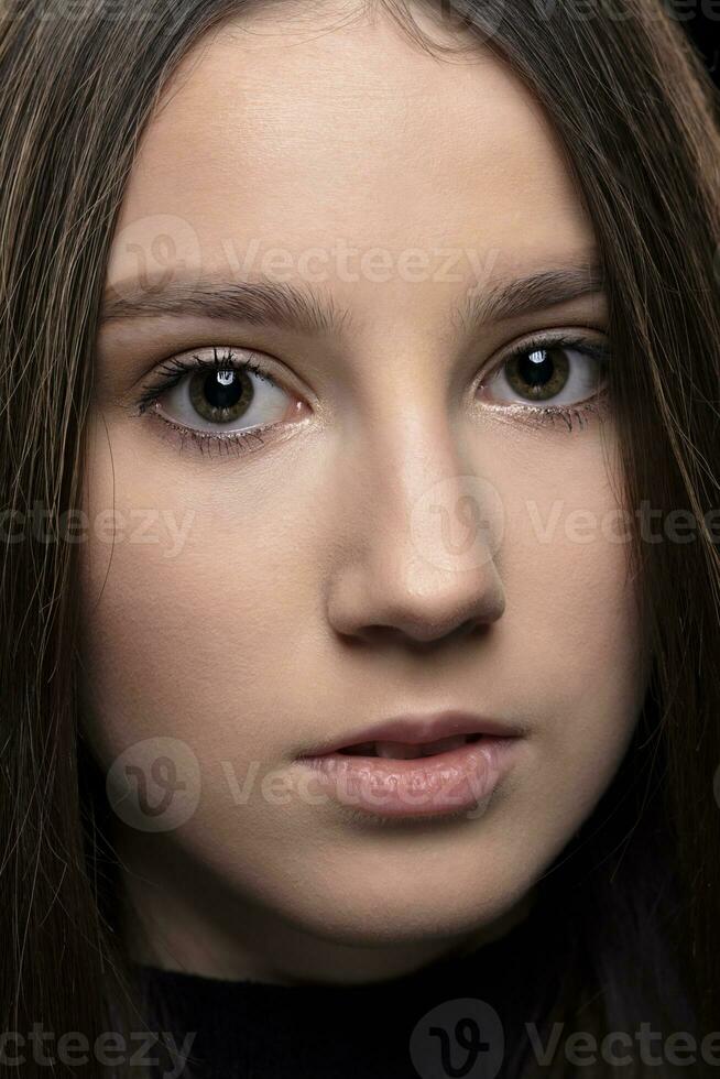 Close-up face of a beautiful young brunette girl. photo