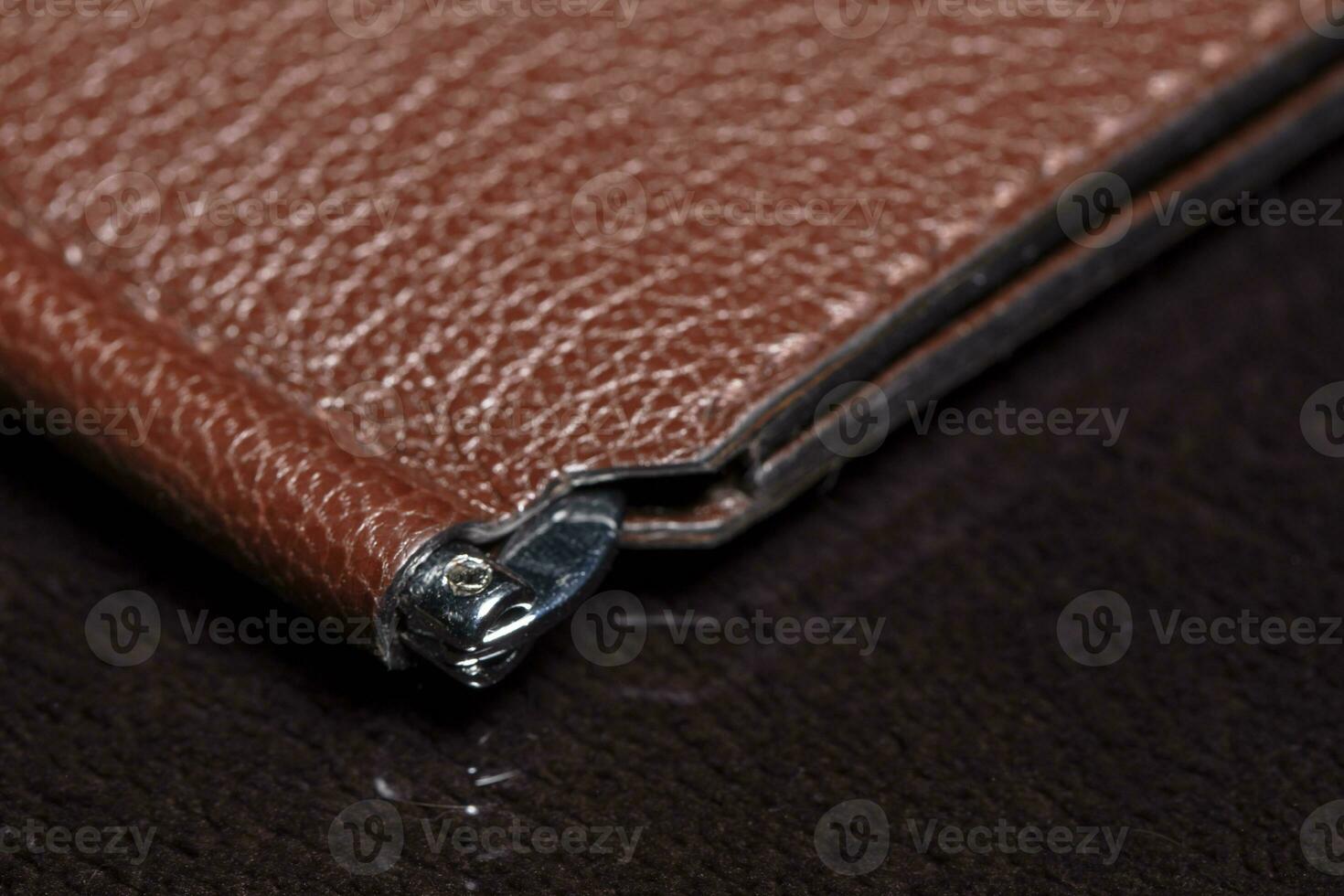 Part of a brown leather wallet or purse close-up. photo