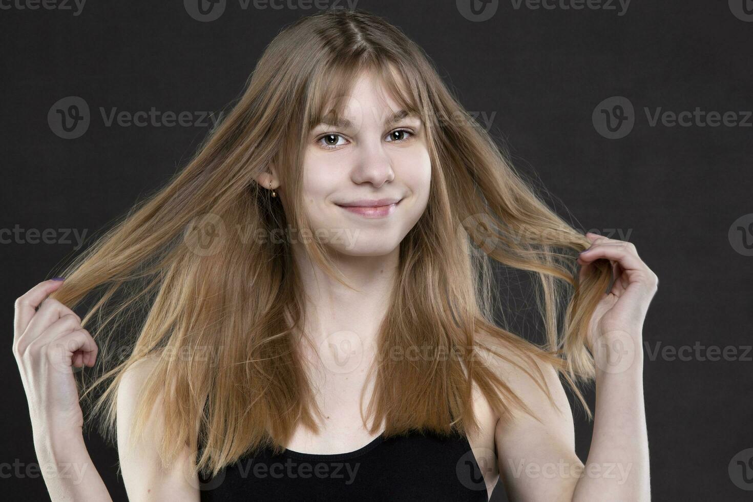 un hermosa Adolescente niña aflojado su pelo mira y sonrisas foto