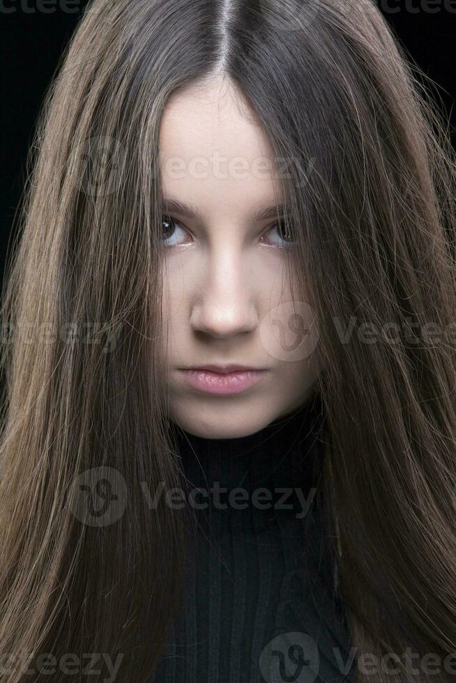 A beautiful brunette girl looks angrily into the camera. photo