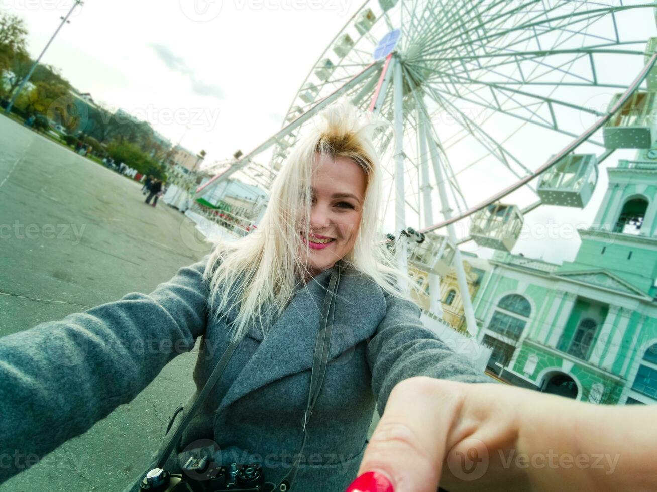 Stylish woman posing near ferris wheel photo