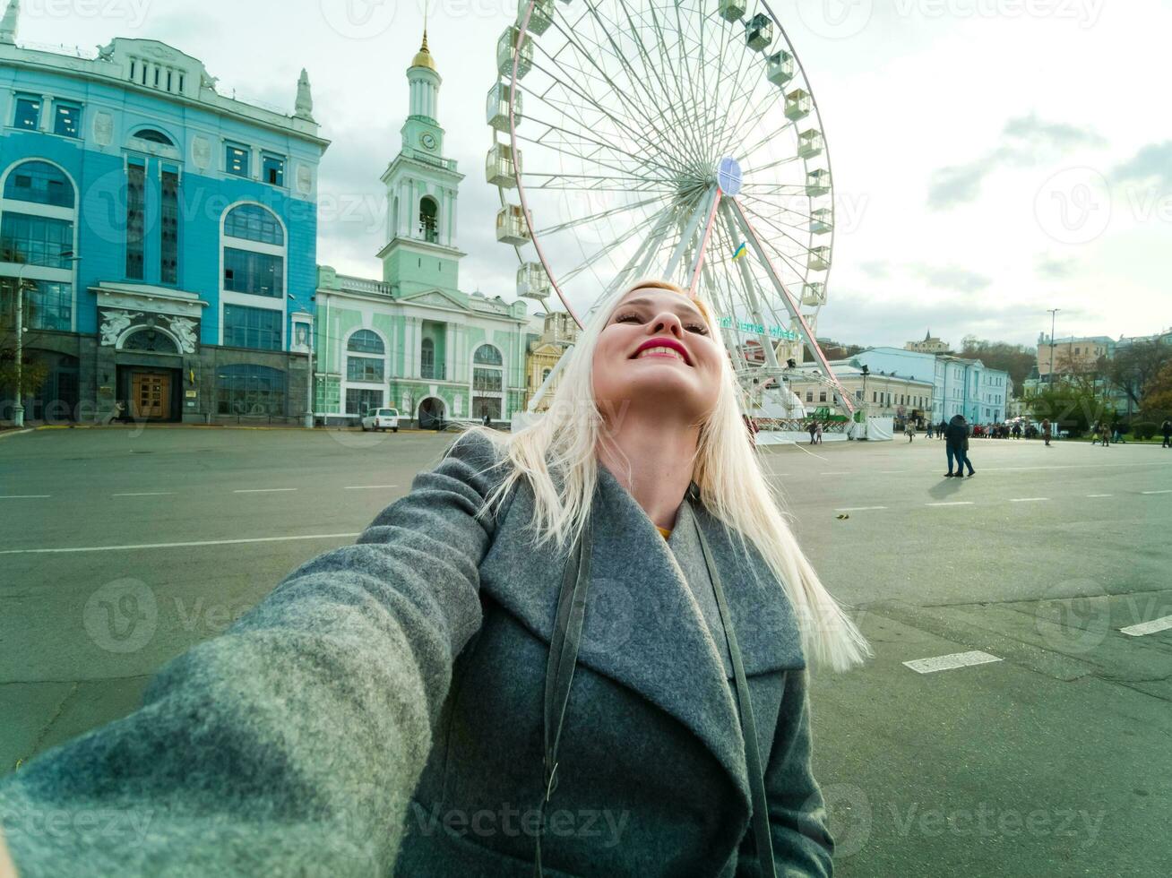 The young girl walks around the city near sights. Ferris wheel. Amusement park. autumn photo