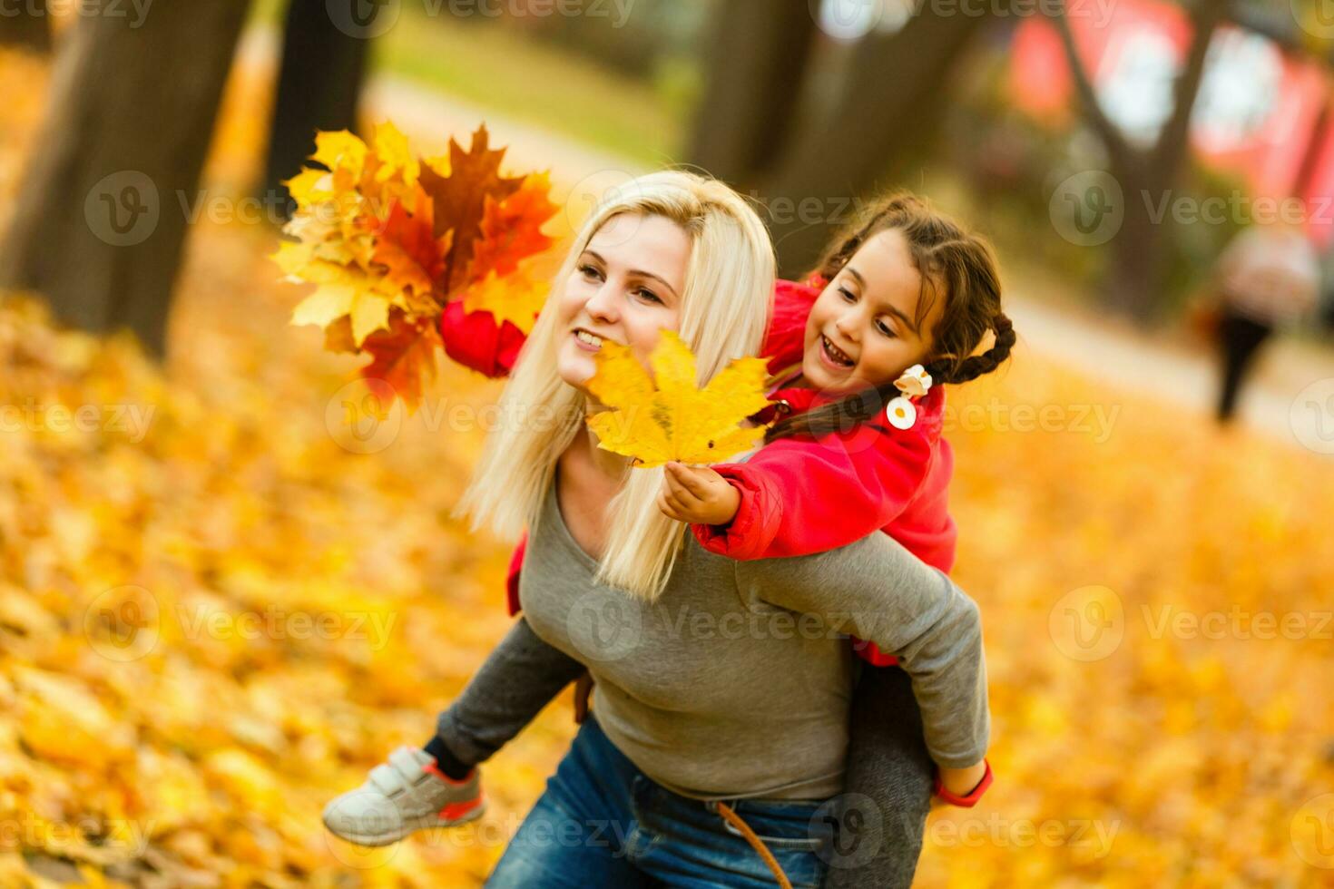 woman with daughter Outdoor having fun in autumn park photo