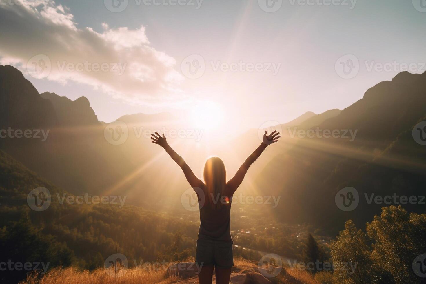 Silhouette of young woman practicing yoga or pilates at sunset or sunrise in beautiful mountain location photo