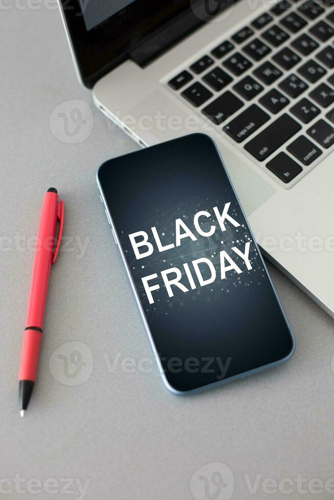 smartphone with black friday banner on the screen lies on wooden desk. Application on screen created in graphic program photo