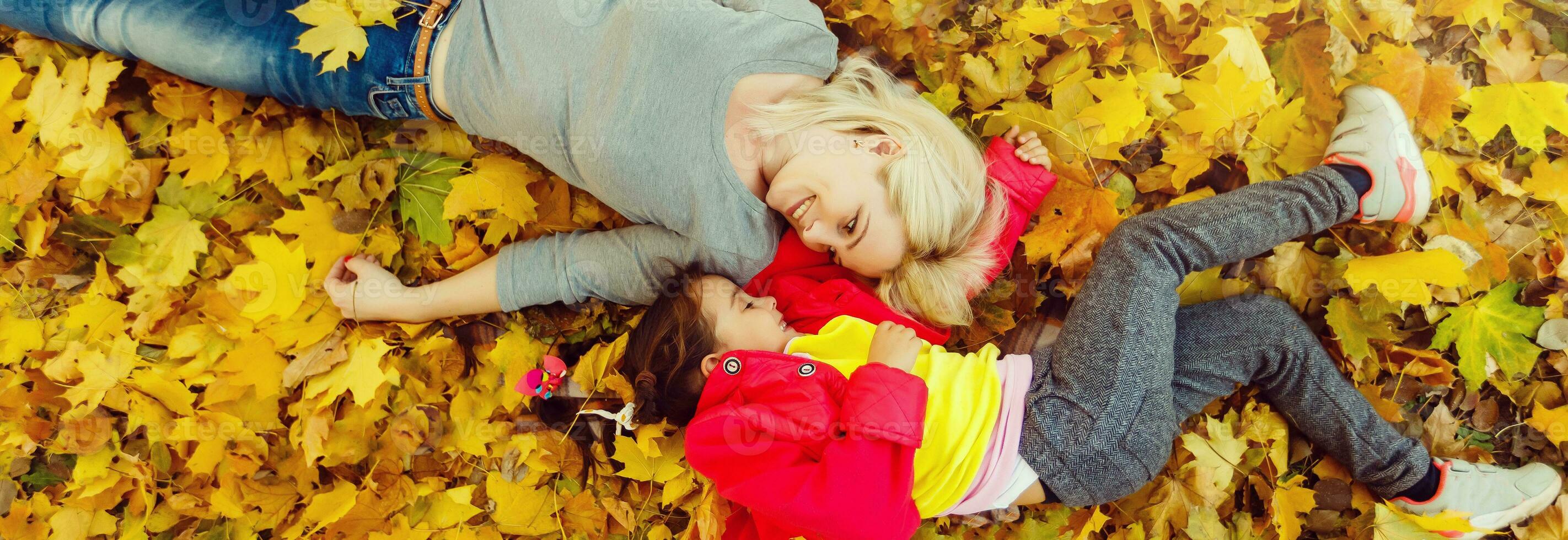 Mother and daughter in autumn yellow park. photo