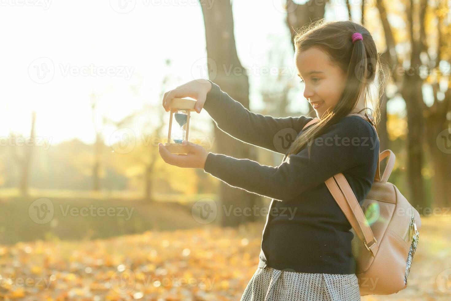 hourglass and autumn dry leaves. Withering time is autumn. photo