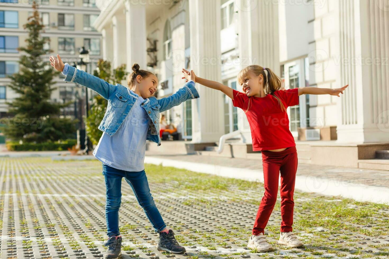 dos pequeño muchachas bailando en el calle foto