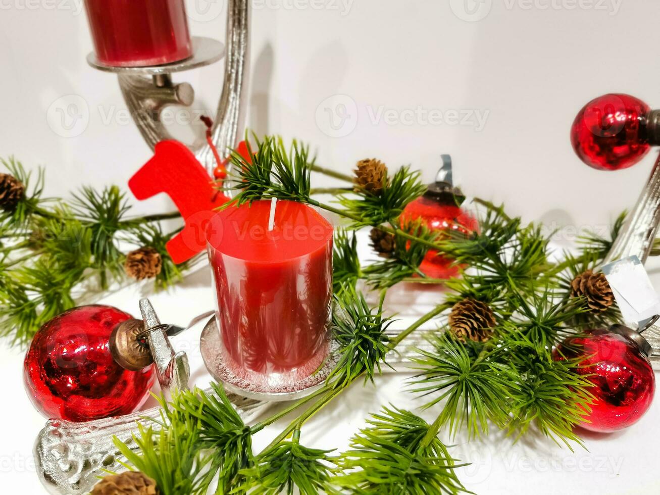red candle and spruce branch photo