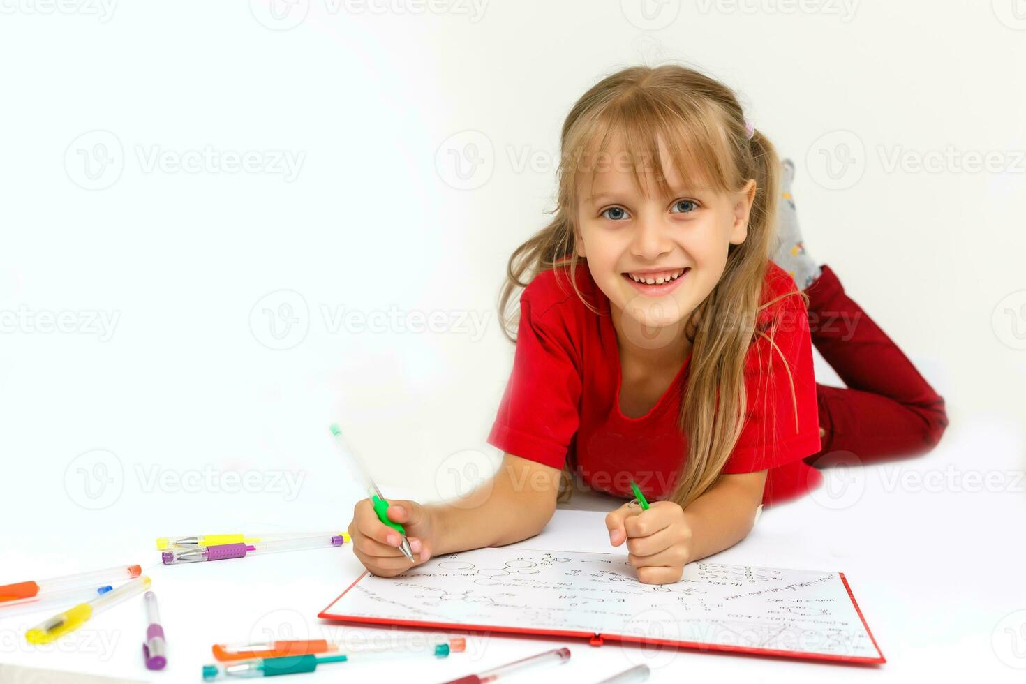 Happy little girl practicing reading laying on the floor in her room photo