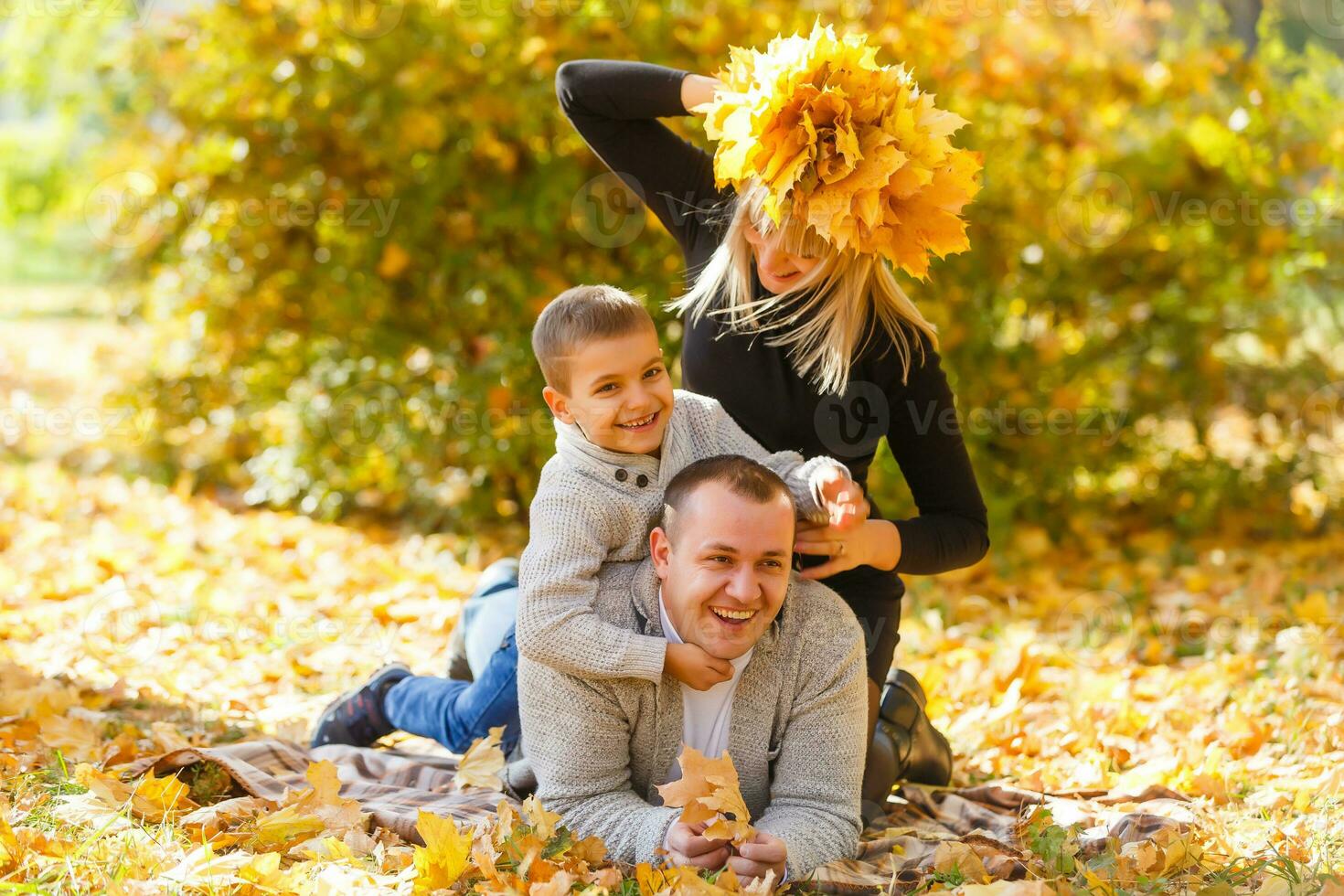 Retrato de familia feliz descansando en el parque otoño foto