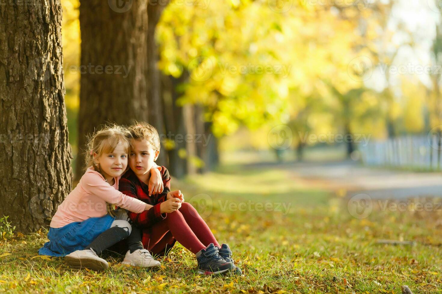 dos pequeño niña amigos Chica de escuela en el parque. foto