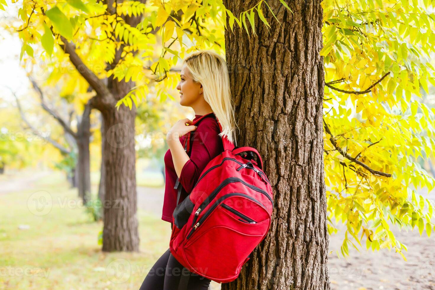 girl with a backpack in the autumn park photo