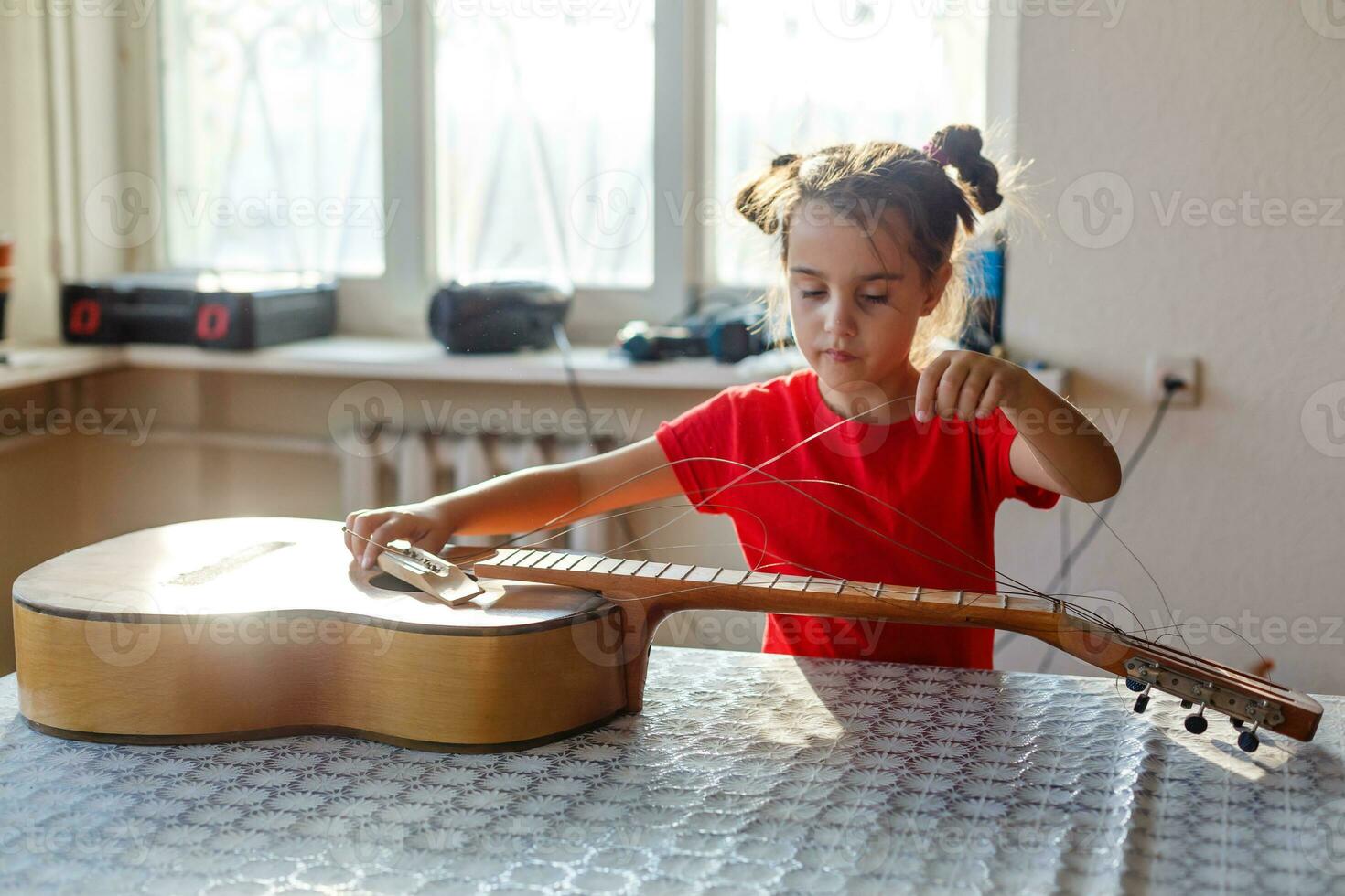little girl holding a broken guitar, guitar repair photo