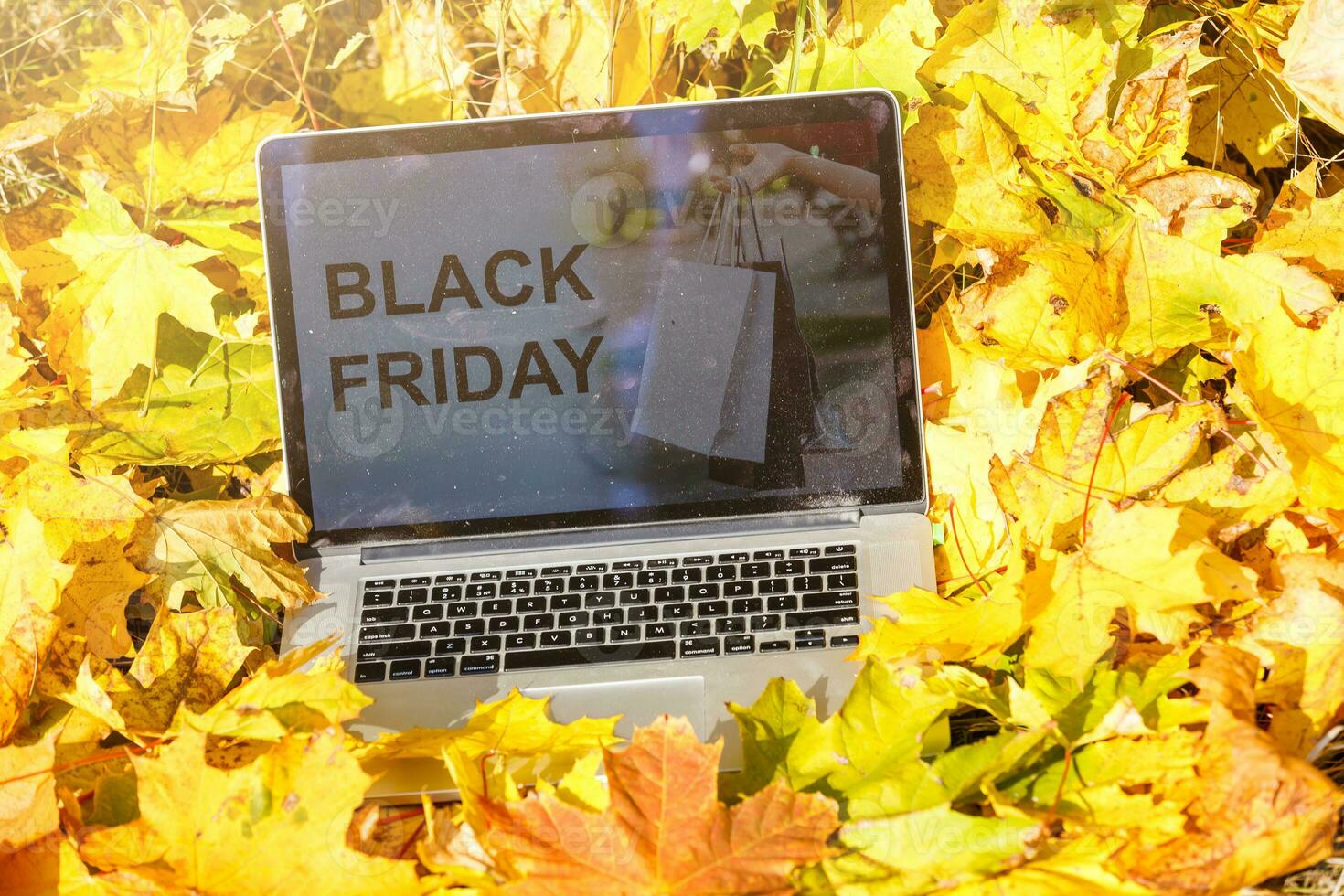 black friday on laptop and autumn leaves photo