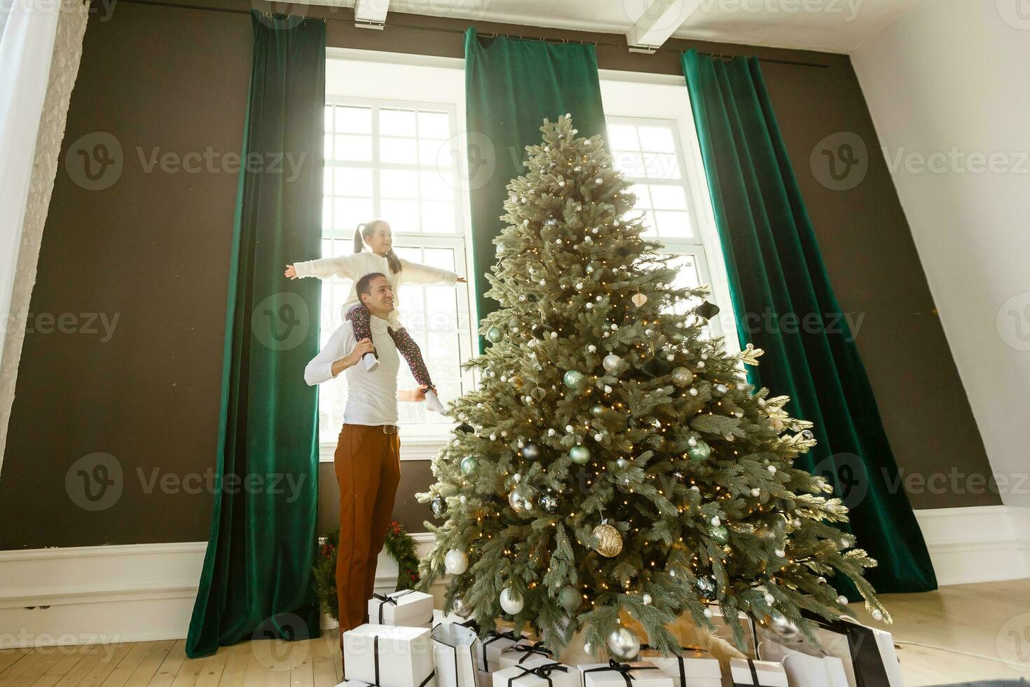 happy young father and his daughter at home with Christmas tree photo