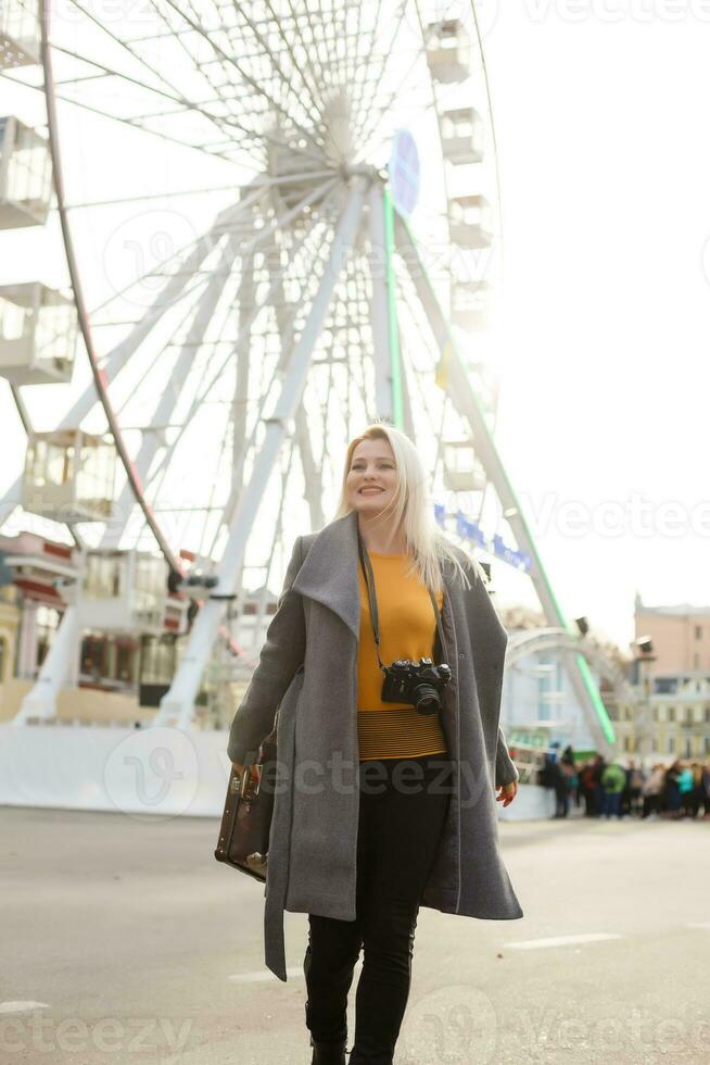 Stylish woman posing near ferris wheel photo
