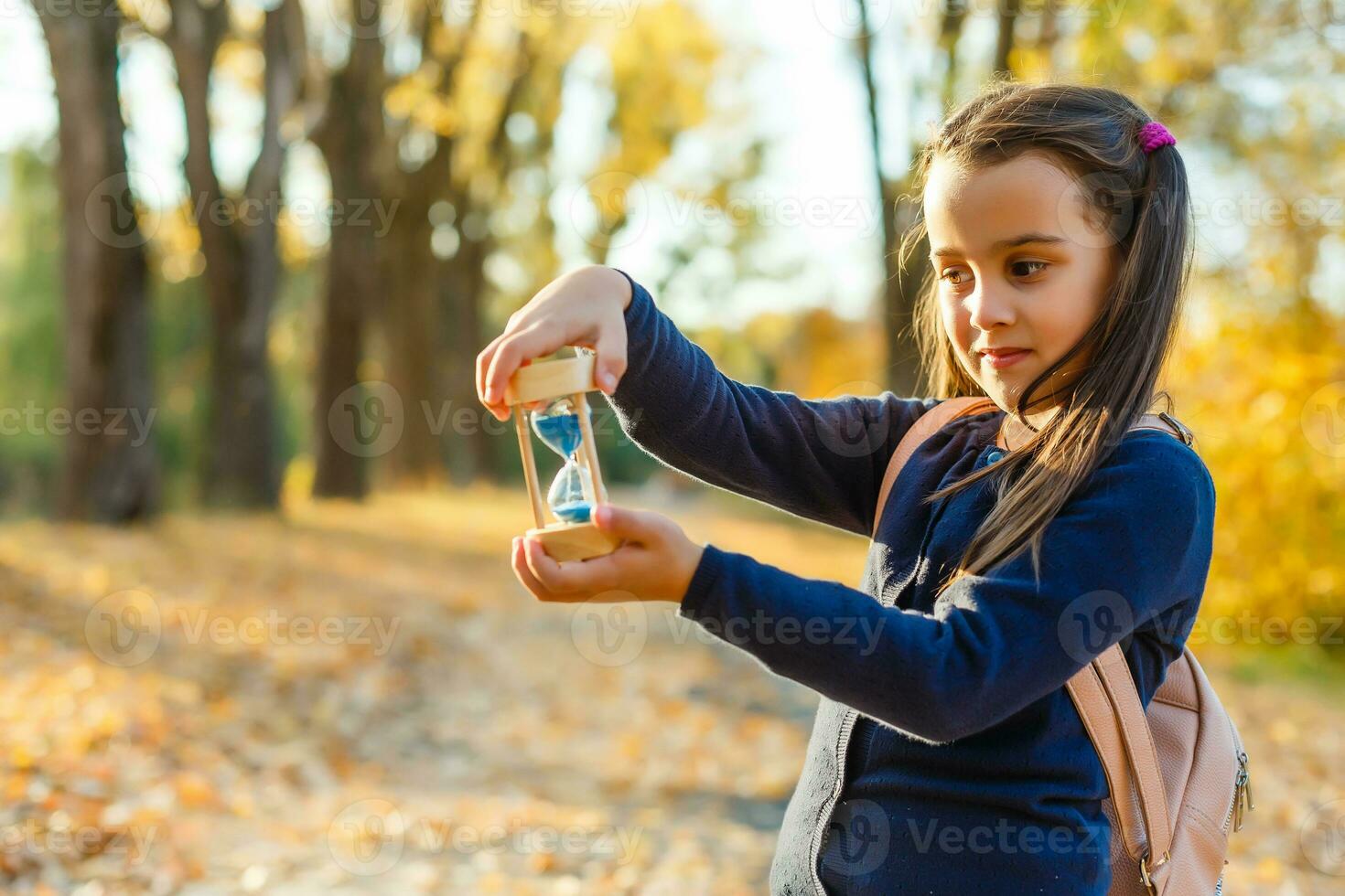 hourglass and autumn dry leaves. Withering time is autumn. photo