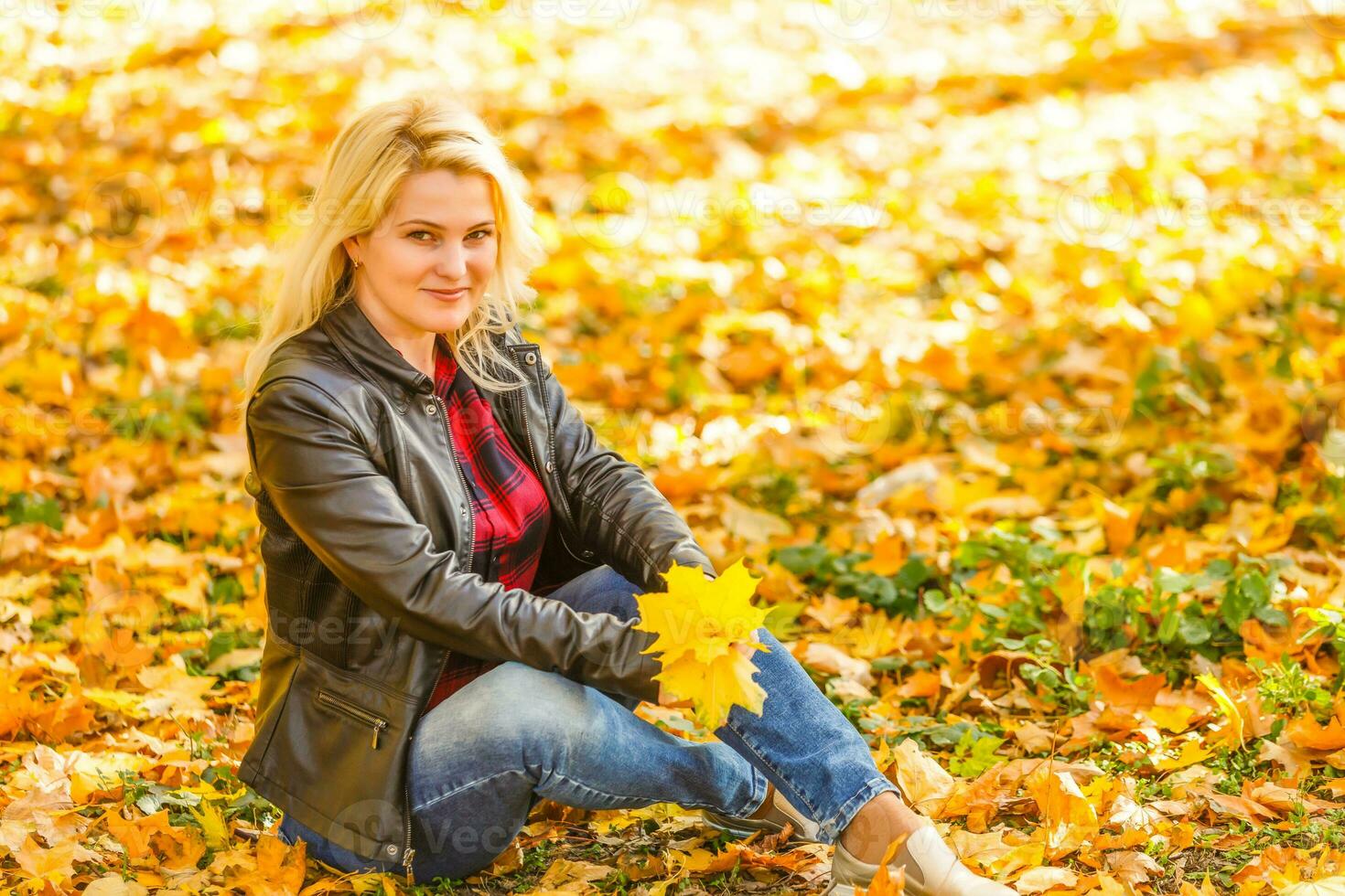 niña sentado en el otoño parque foto