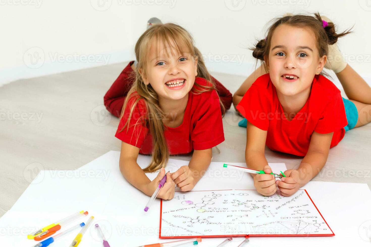 Two girls read book isolated on white photo