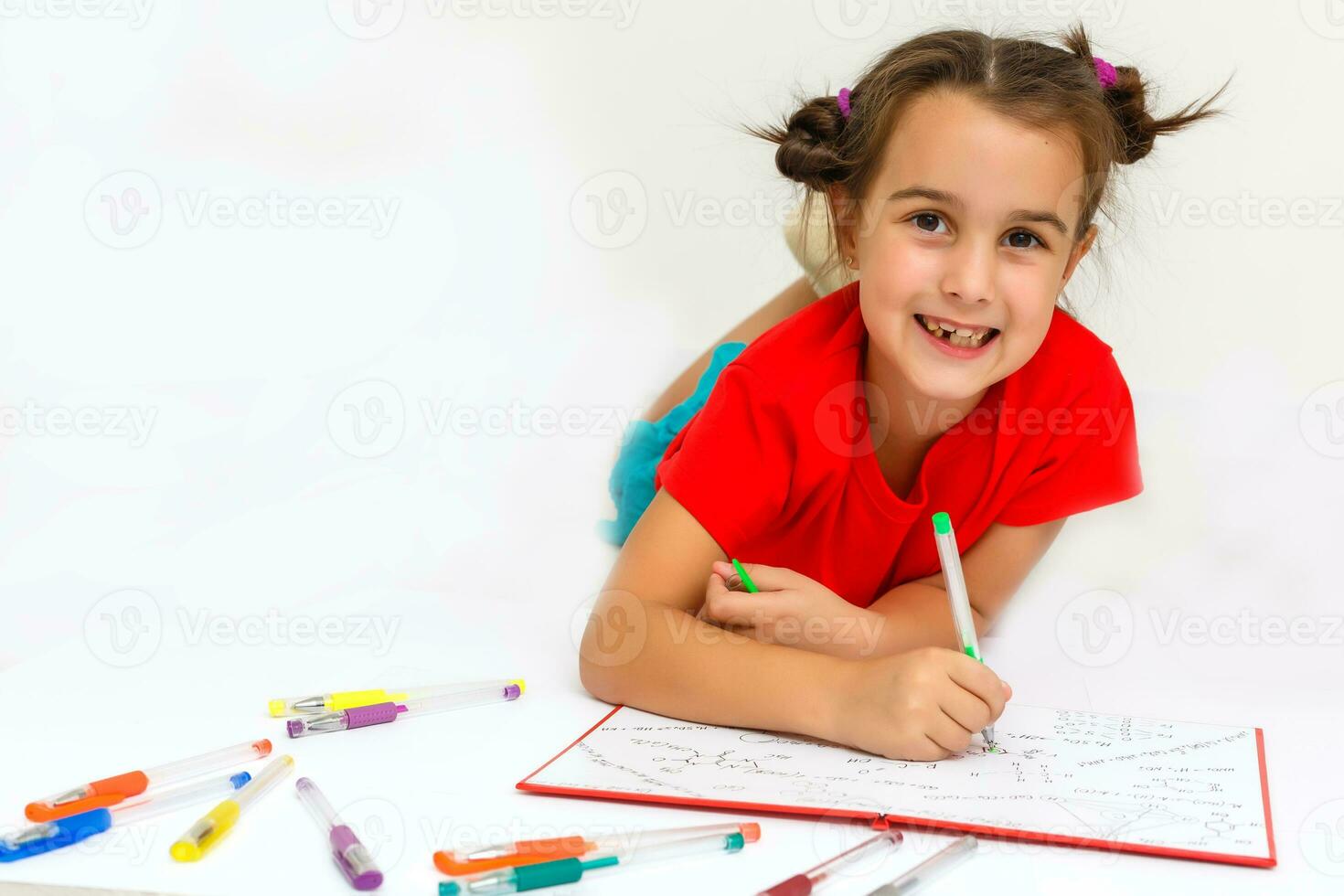 Happy little girl practicing reading laying on the floor in her room photo