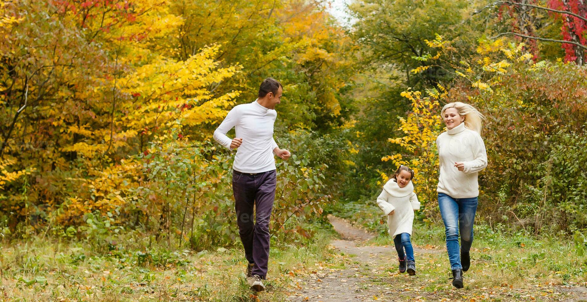 Picture of lovely family in autumn park, young parents with nice adorable daughter playing outdoors, have fun on backyard in fall, happy family enjoy autumnal nature photo