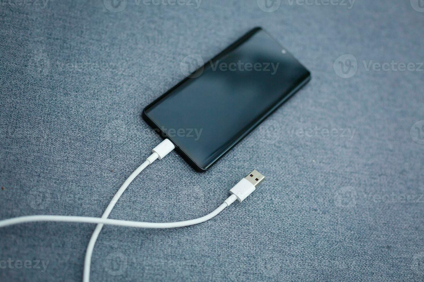 Mobile smart phones charging on gray background photo