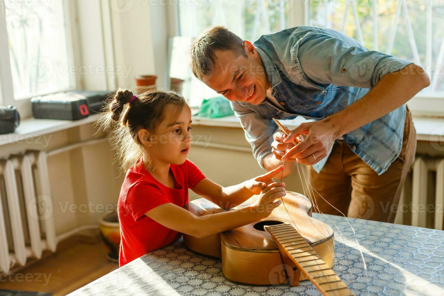 father and daughter repairing a guitar photo