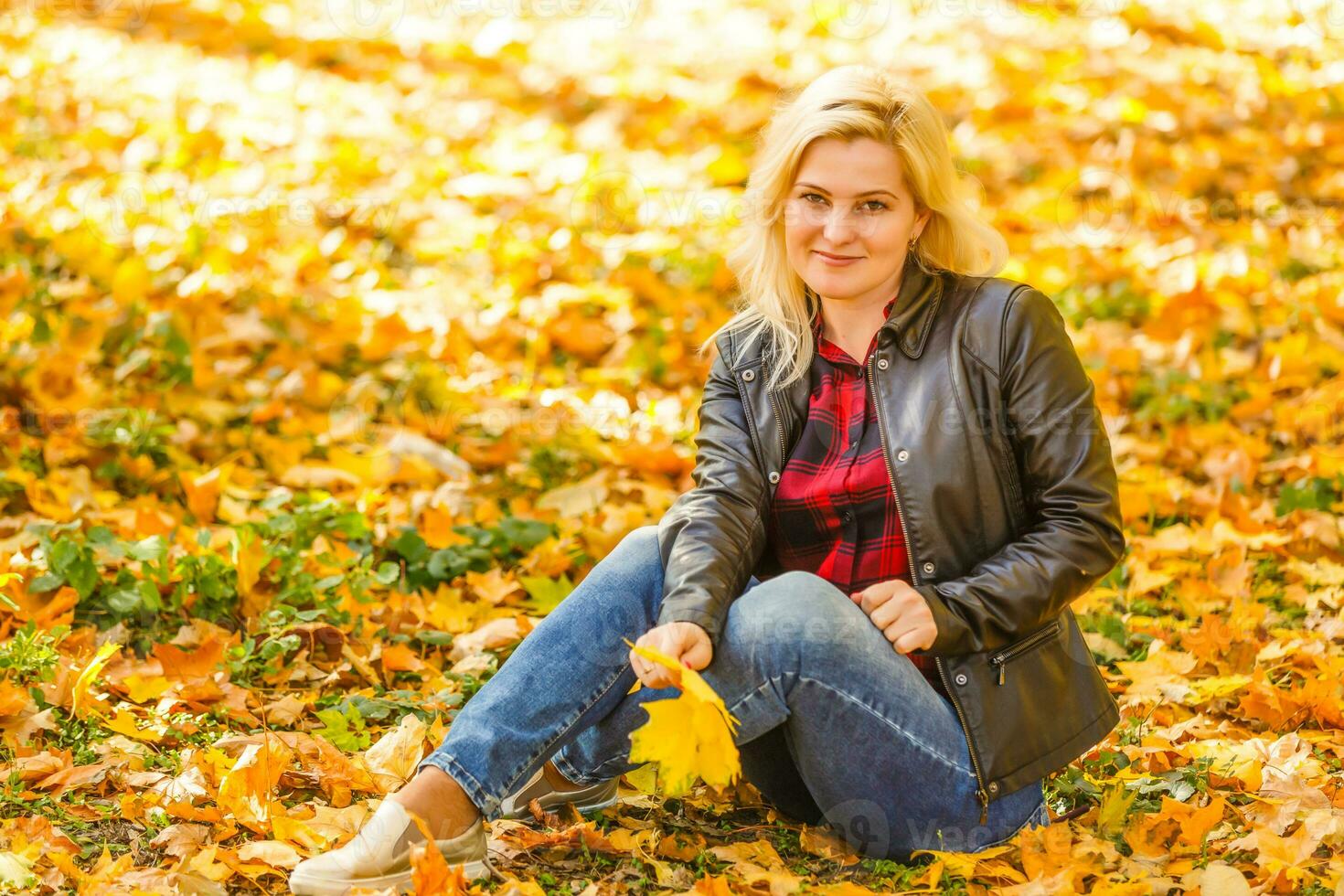 girl sitting in the autumn park photo