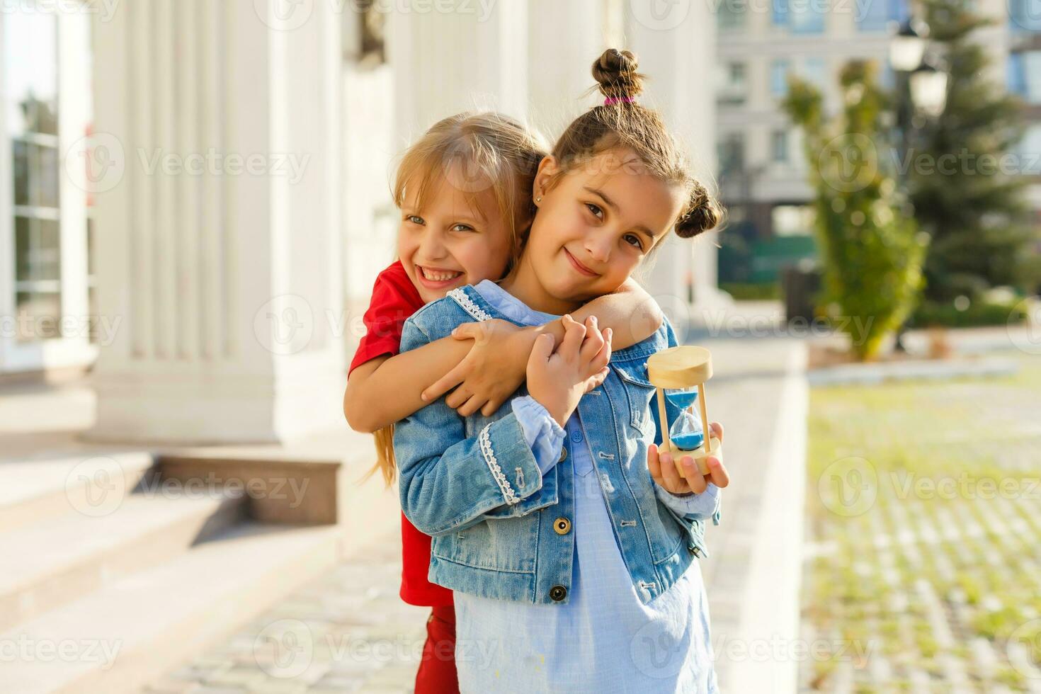 dos pequeño muchachas jugar reloj de arena foto