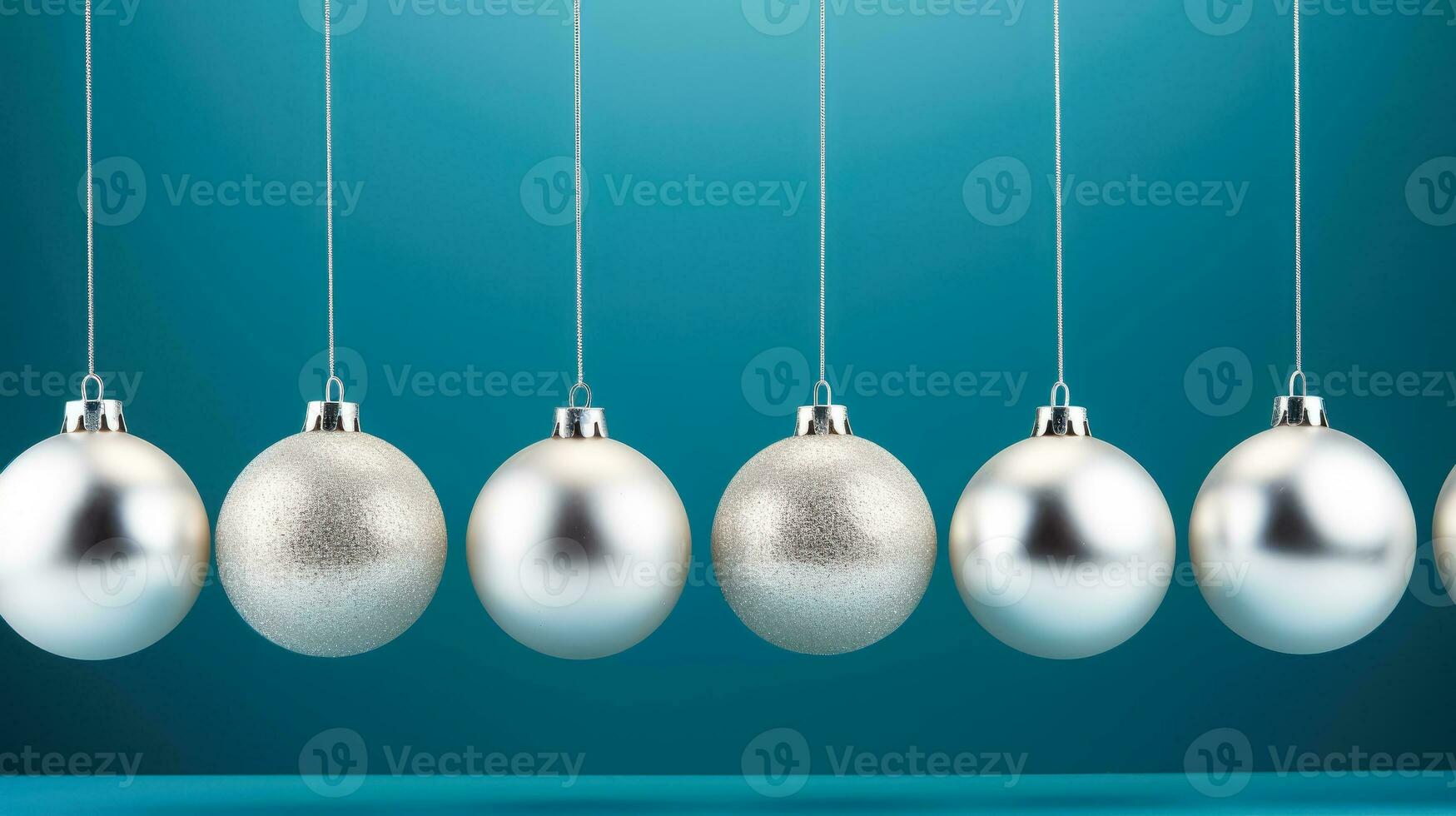 Silver christmas baubles isolated on a vibrant blue background photo