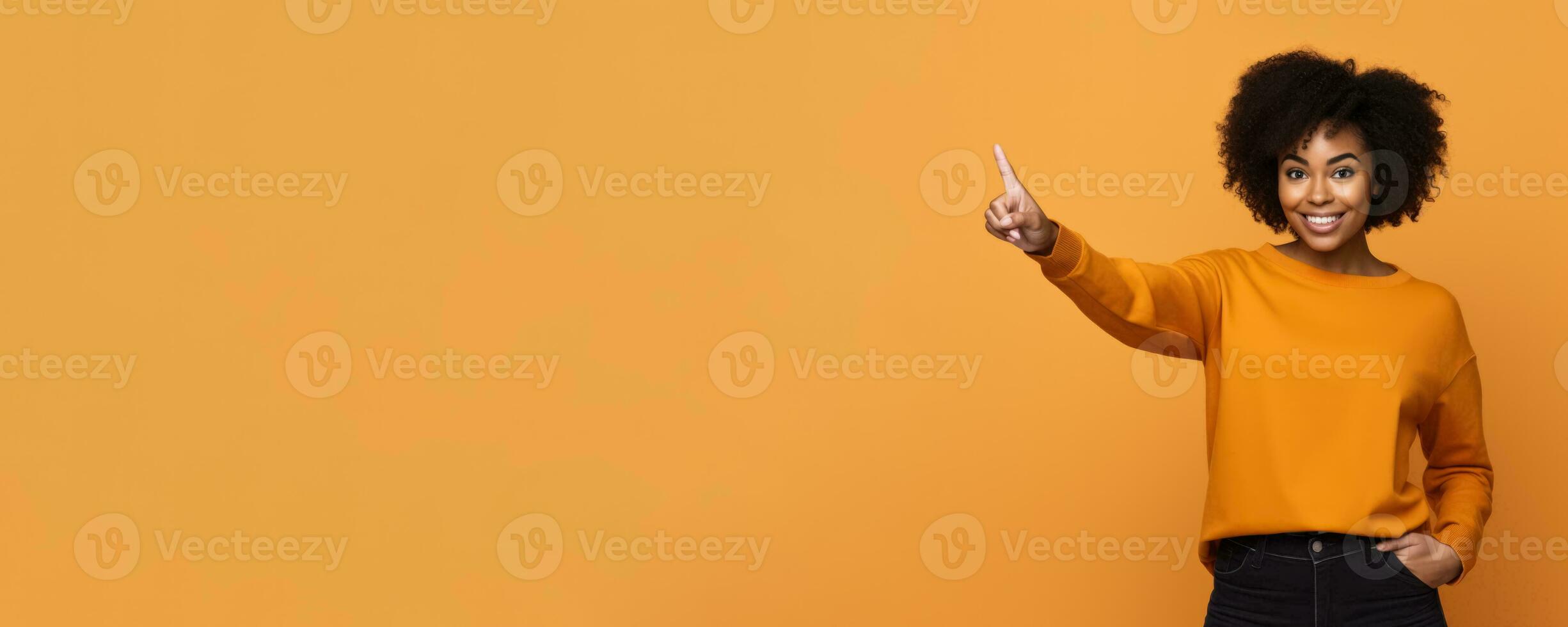 African American woman pointing to empty space orange background photo