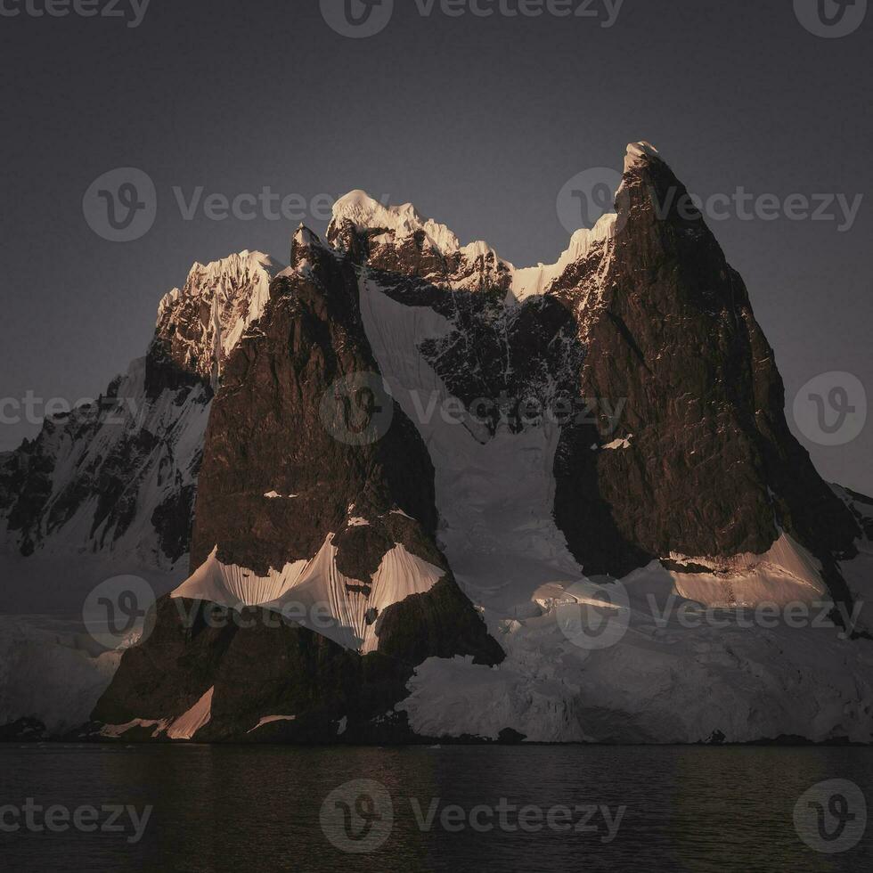 Lemaire strait coastal landscape, mountains and icebergs, Antarctic Peninsula, Antartica. photo