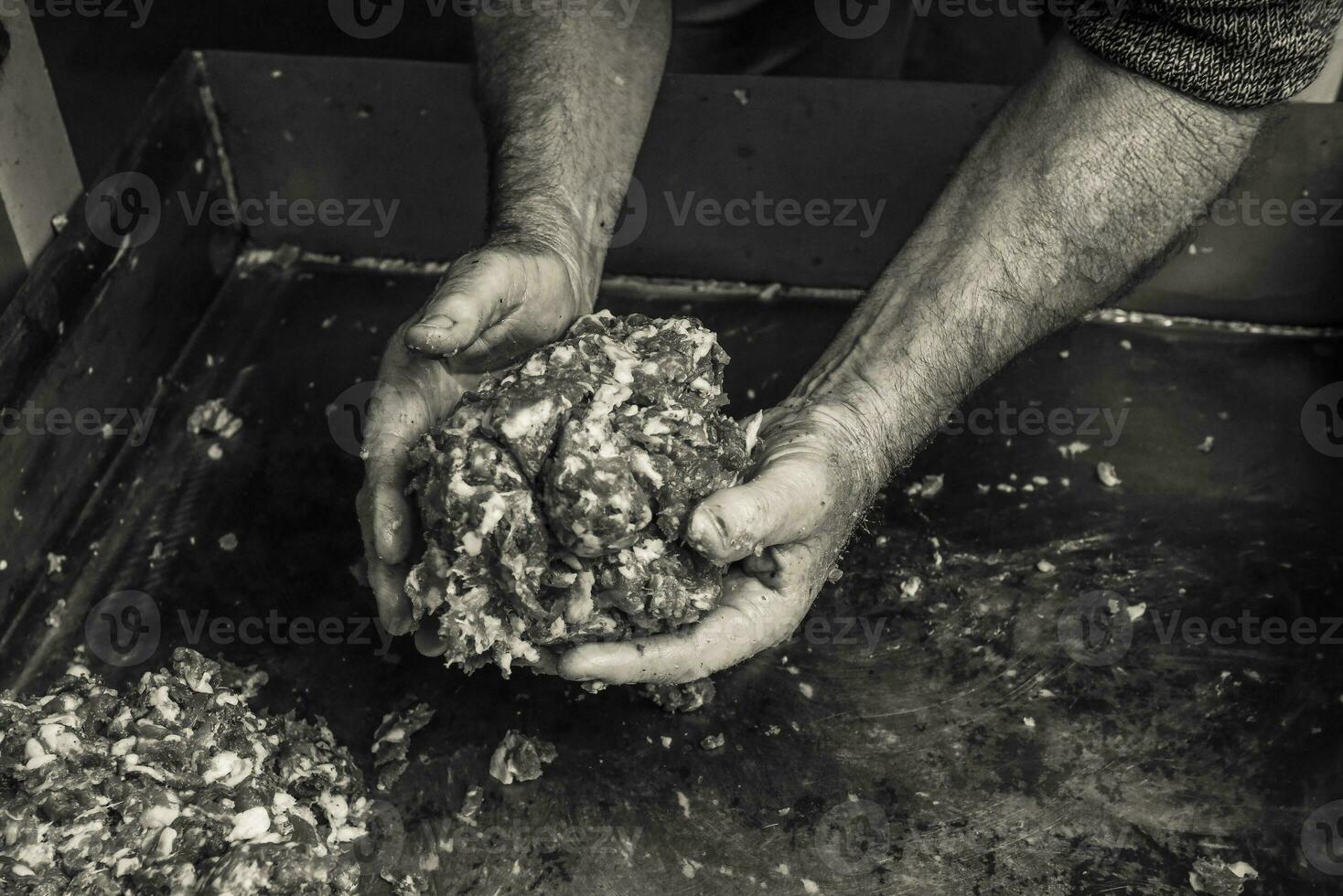 manos cocinando,picado carne, salchicha tradicional preparación, pampa, argentina foto