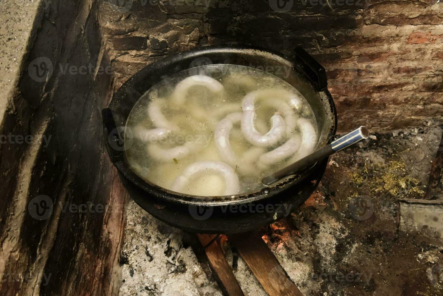 Cooking white blood sausage, in an iron saucepan, on a stove. photo