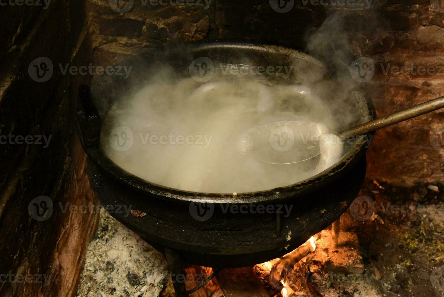 Cooking white blood sausage, in an iron saucepan, on a stove. photo