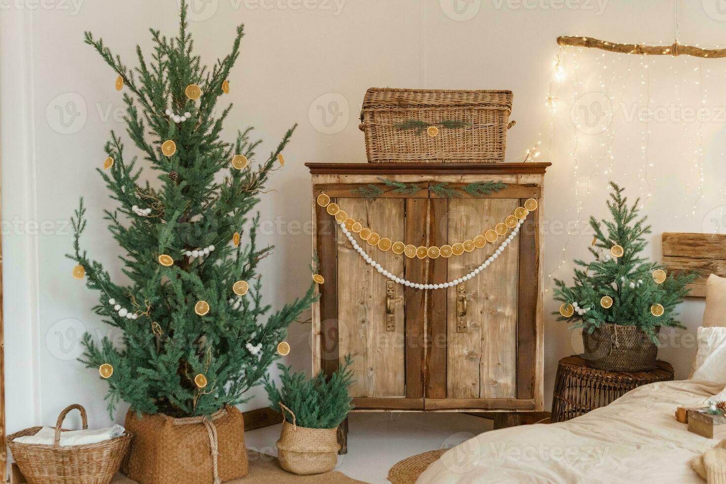 Cozy interior decorated for Christmas in Scandinavian style. Live fir trees decorated with natural ornaments made of dried oranges photo