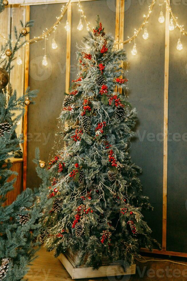 hermosamente decorado Navidad árbol y un montón de brillante guirnaldas y ligero bombillas preparando para el Navidad fiesta a hogar. foto