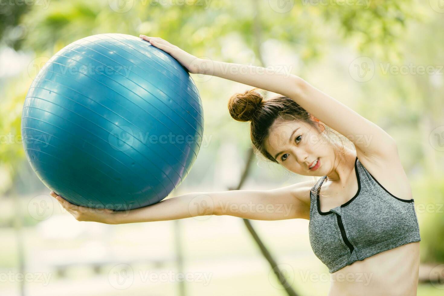 beautiful asian happy woman play enjoy fun with fit ball exercise at park outdoor slim and healthy girl workout activity. photo