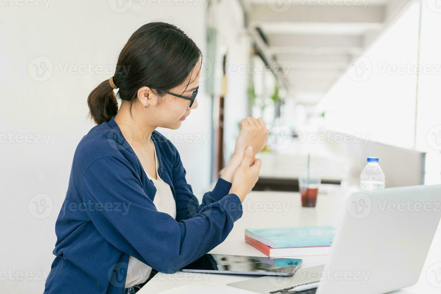 Young teen asian woman muscle tendon joint wrist pain from using laptop computer massage for pain relief. photo