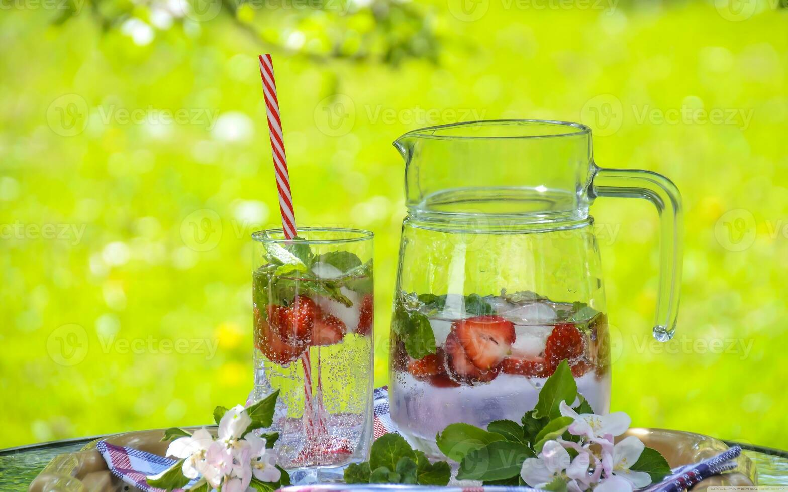 Strawberry lemonade pitcher, lemonade with lemon, lime, and strawberries, Homemade, in pitcher and glass, with many crushed ice, mint leaves, lemonade with strawberry and lemon, nature background, photo