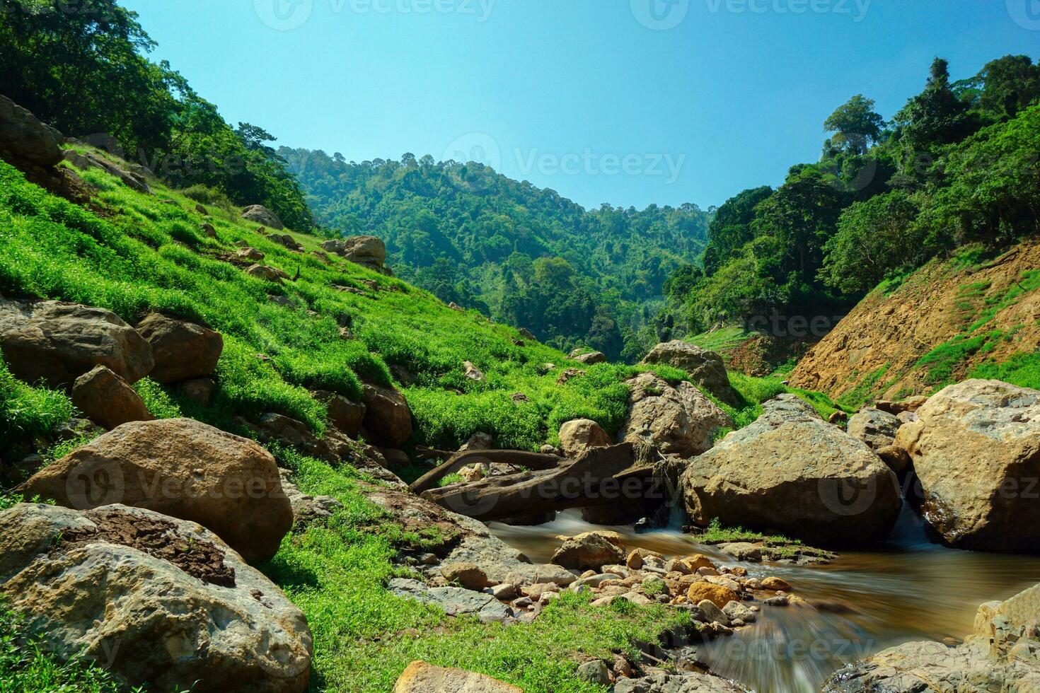 río arriba ver en parte superior de el represa rodeado por montañas y lozano naturaleza foto