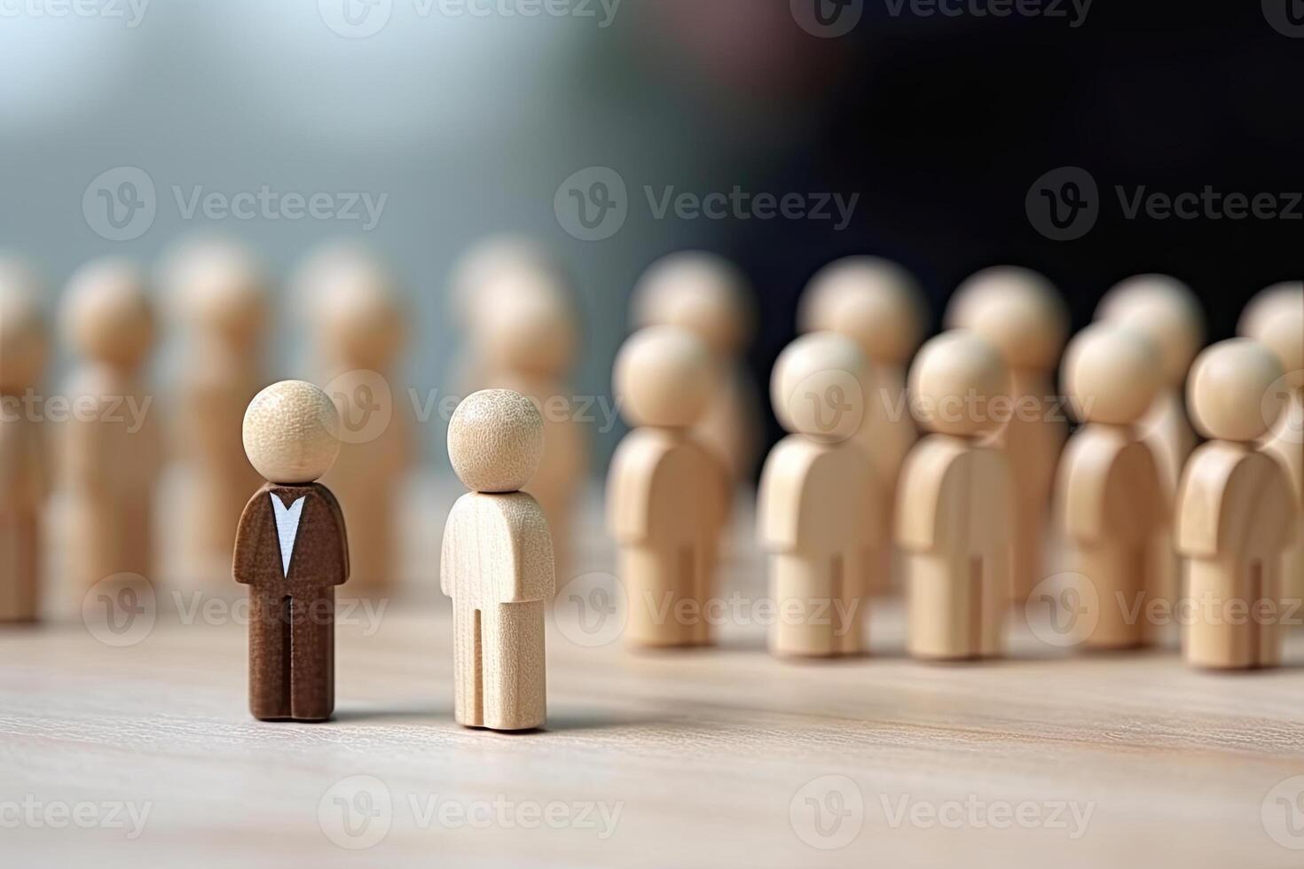 Figurine of a businessman standing in front of a group of people. photo