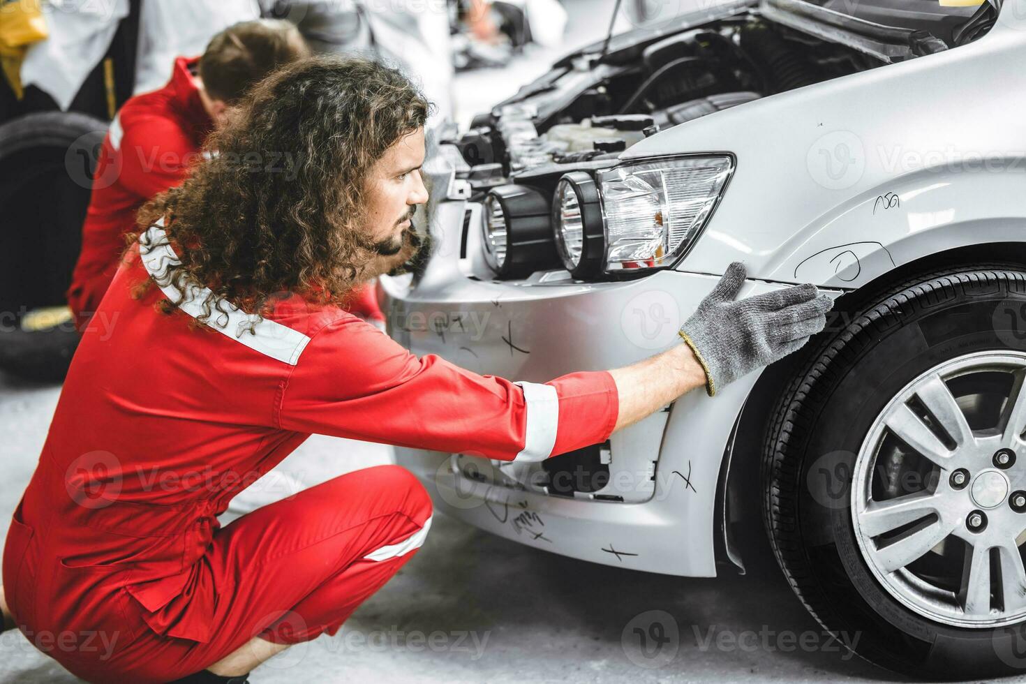 Mechanic garage auto workshop team working service repair fix damaged front bumper accident car photo