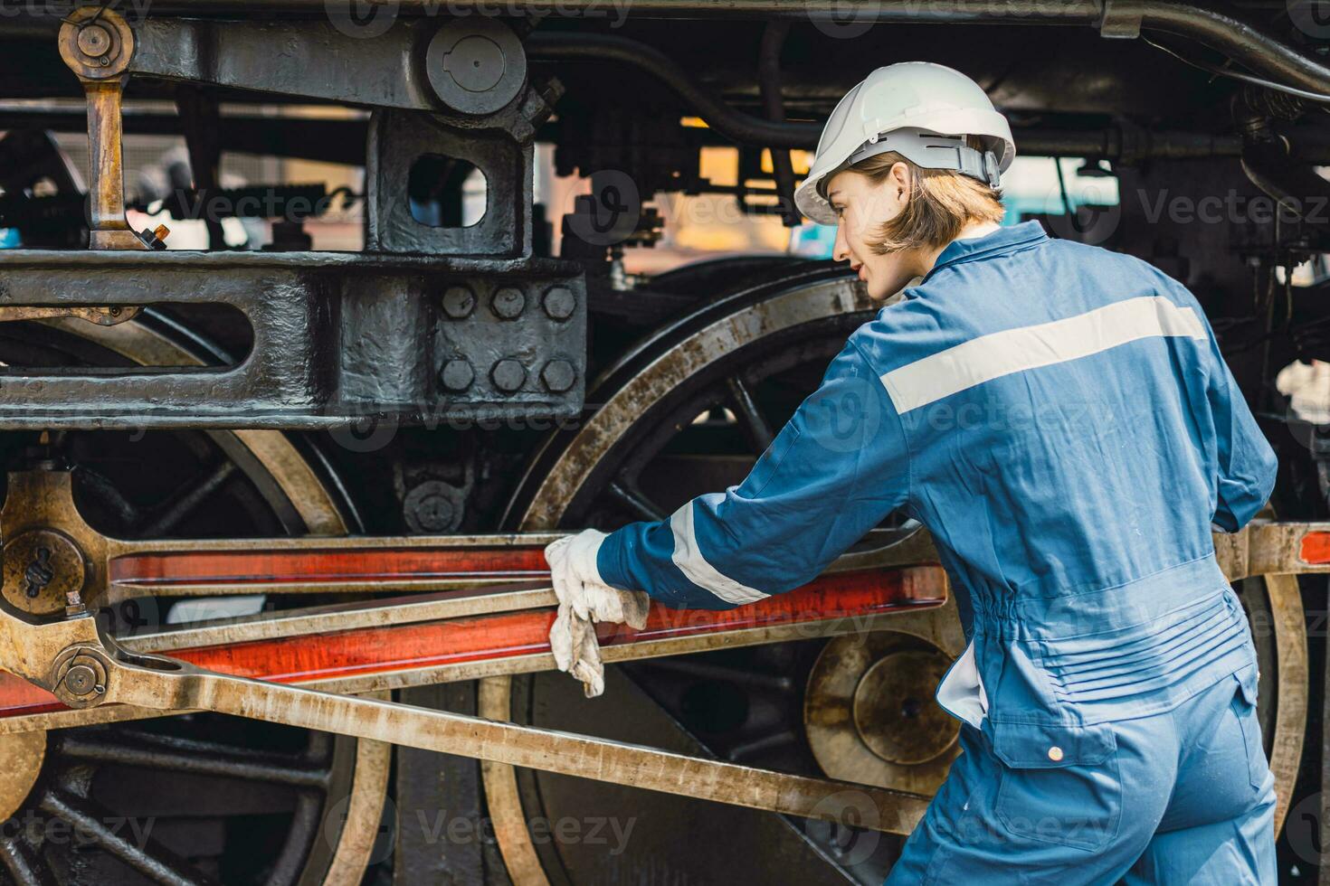 Train engineer team working service maintenance old dirty vintage classic steam engine locomotive in train repair workshop at train station. photo